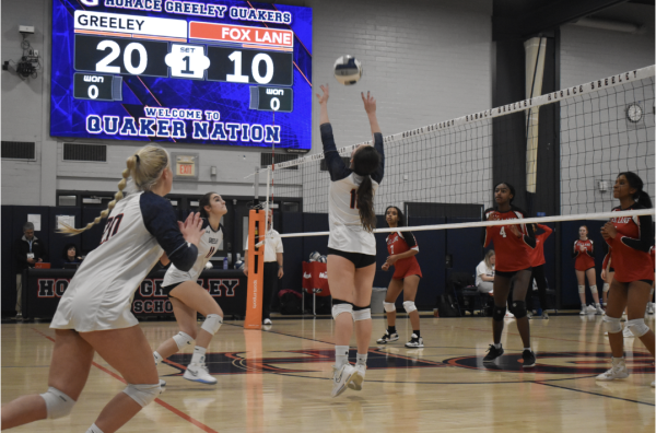 Junior Ace Tillotson (10) sets a ball for Junior Claire Fallon (11)